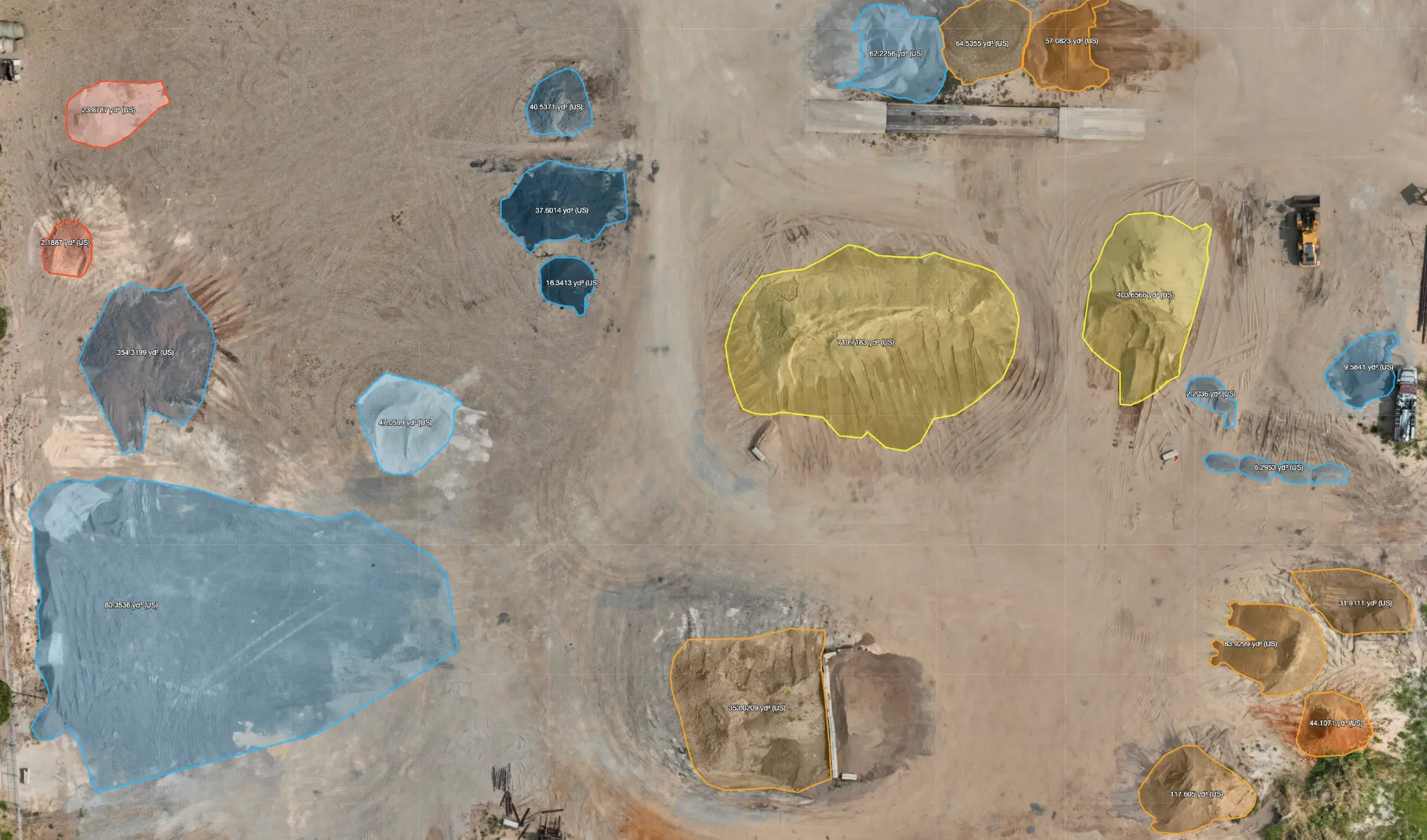 Orthomosaic with stockpiles outlined and labeled with measured volumes in cubic yards